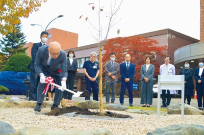 写真：６０周年を記念してヤマボウシの苗を植樹する千葉院長