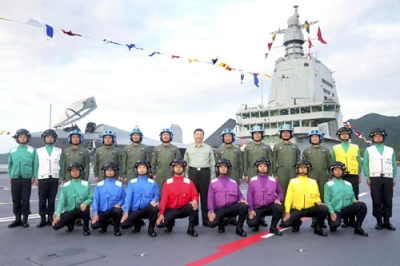 写真：中国軍の新型空母「福建」が就役し、パイロットらと記念撮影する習近平国家主席（後列中央）＝５日、中国海南省三亜市（新華社＝共同）