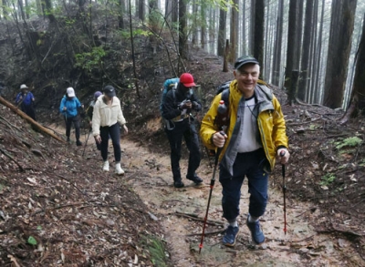 写真：熊野古道を案内するティム・デットマーさん（手前）＝９月、和歌山県高野町