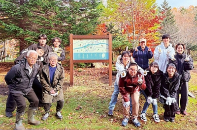 写真:ヤマボウシの苗(右奥)を植えた参加者ら(提供写真)