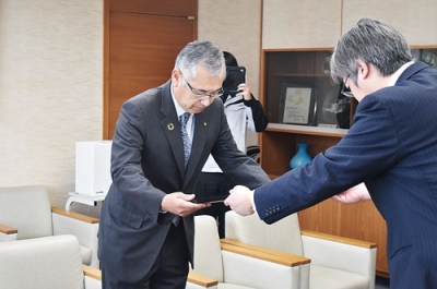 写真:大滝基幹集落センターの駐車場整備奉仕をしたとして、感謝状を受け取る大同舗道の金子社長
