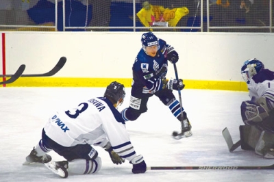 写真：【日鉄室蘭－ダイナックス】第３ピリオド終盤、６点目のシュートを放つ日鉄室蘭・村上（中央）＝新和産業アイスアリーナ室蘭