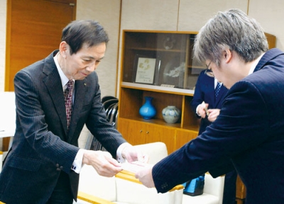 写真：目録を手渡す今井代表取締役（左）