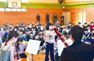 写真：タクトを振って指揮者気分を味わう児童