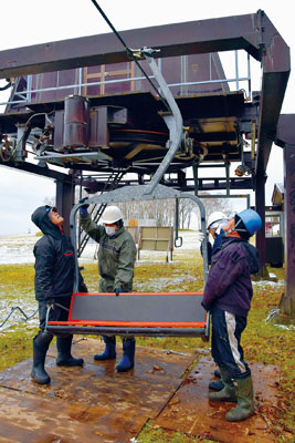 写真：だんパラスキー場でチェアリフトの椅子を取り付けるスタッフ