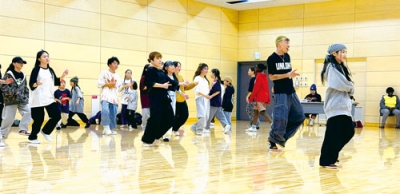 写真：「ＵＮＬＯＫＫ」メンバーと振り付けの練習を行う参加者