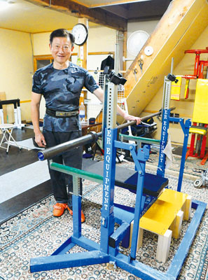 写真:本番で使用するベンチプレス台と大会をPRする川越代表