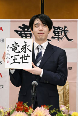 写真：竜王戦５連覇から一夜明け、色紙を手に写真に納まる藤井聡太竜王＝１４日午前、京都市下京区