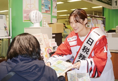 写真：来庁者にリーフレットを配る輪島選手