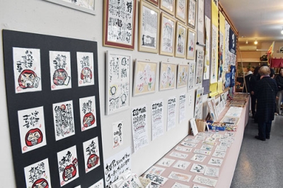 写真：心温まるメッセージやイラストが並ぶ己書作品展