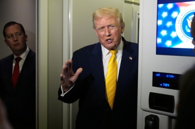 写真:米大統領専用機内で記者団に話をするトランプ大統領=14日(AP=共同)