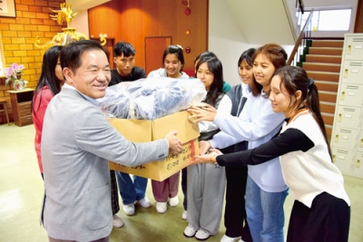 写真：市民有志から寄贈された冬服を受け取る留学生たち