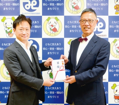 写真:渡邊会長(右)に目録を手渡す橋本会長