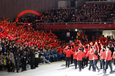写真：「東京デフリンピック」の開会式で、入場する選手らを見守る日本選手団（左）＝１５日、東京体育館