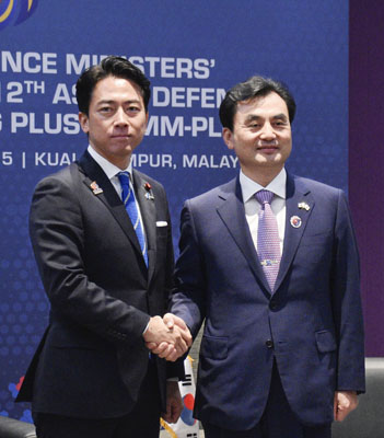 写真:会談で握手する小泉防衛相(左)と韓国の安圭伯国防相=1日、クアラルンプール(共同)