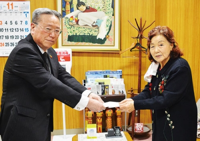 写真:安宅教育長(左)に寄付金を手渡す坊良さん