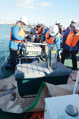 写真：通信機材を巡視艇りゅうせいに積み込む通信事業者社員ら