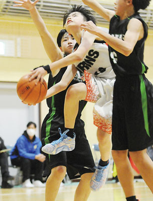 写真:ファウルを受けながらシュートを放つアイアンズ・高橋(中央)