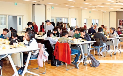 写真：会話を楽しみながら料理を味わう子どもや地域住民たち