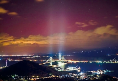 写真：関さんが撮影した「低緯度オーロラ」。淡く赤い光がまちを包む。（提供写真）