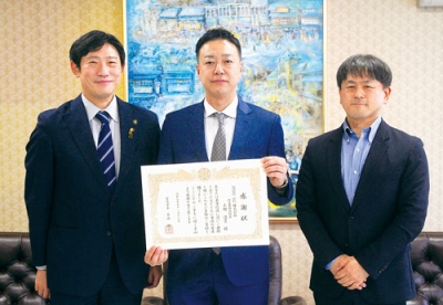 写真：青山市長（左）から感謝状を受け取った上村社長（中央）