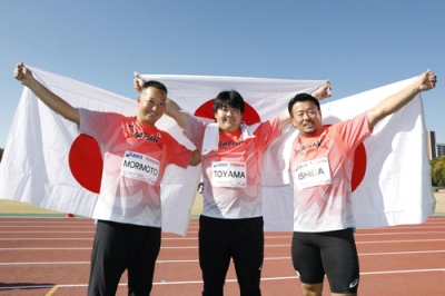 写真：「東京デフリンピック」の陸上男子ハンマー投げで表彰台を独占した日本勢。日の丸を掲げる金メダルの遠山莉生（中央）、銀メダルの森本真敏（左）、銅メダルの石田考正＝２０日、大井ふ頭中央海浜公園陸上競技場