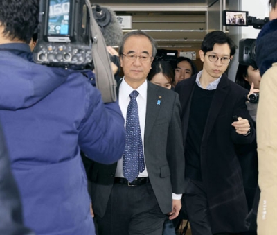 写真：記者団に囲まれながら新潟県庁に登庁する花角英世知事（左）＝２１日午前