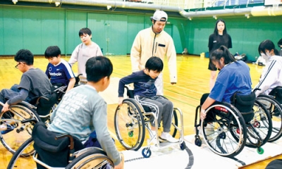 写真：マットを使い、車いすを操る技術を上達させる児童ら