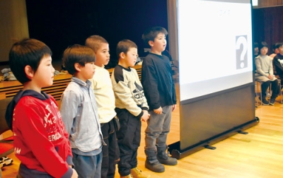 写真：バスツアーで訪れた観光客へ町の魅力を堂々と伝える豊浦小３年生
