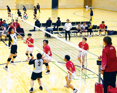 写真：ネット際で激しい攻防を繰り広げる選手たち＝２２日、栗林商会アリーナ