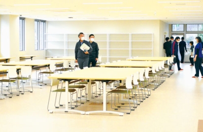 写真:新棟2階の精神科作業療法室を見学する関係者ら