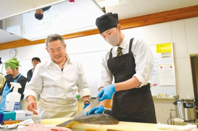 写真：マツカワカレイの五枚おろしに挑戦する生徒