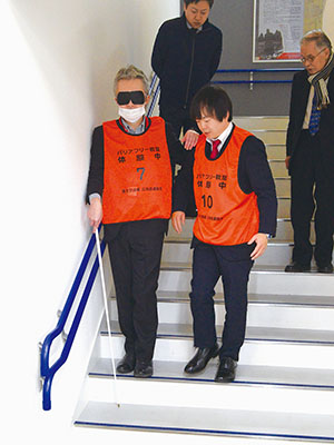 写真:アイマスクを着け視覚障がい体験をする参加者