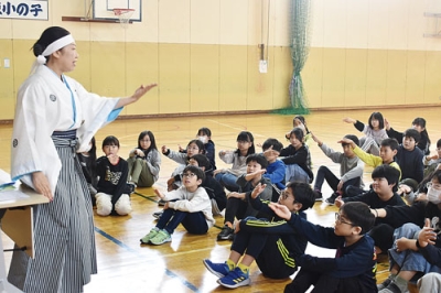 写真：横内さん（左）と「さんさ時雨」の振り付けを体験する児童たち