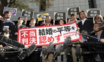 写真：同性カップルら８人が国に損害賠償を求めた東京第２次訴訟の控訴審判決を受け「不当判決」などと書かれた紙を掲げる原告ら＝２８日午前、東京高裁