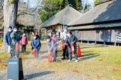 写真：水消火器で訓練する有珠善光寺の関係者＝有珠町