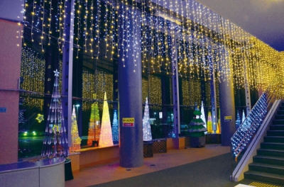 写真：天井からつり下げられたＬＥＤの光を反射させるホワイエの窓ガラス