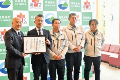 写真：感謝状を受け取る北紘建設の河島専務取締役と社員たち