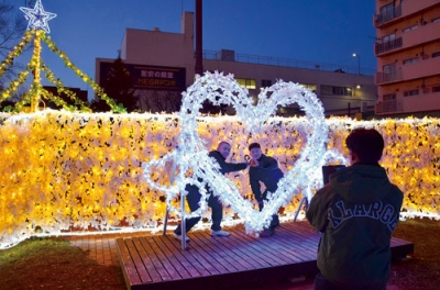 写真：ハート型のイルミネーションと共に記念撮影する高校生たち＝２９日午後４時半ごろ