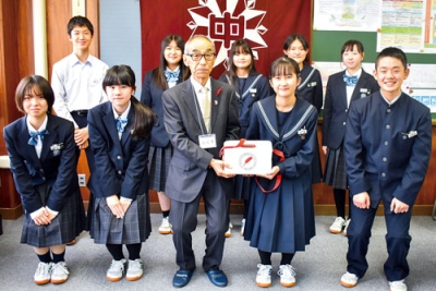 写真：菊池会長（前列左から３番目）に募金箱を手渡す伊達中生徒会メンバー