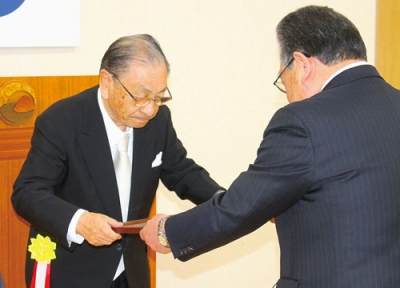 写真：洞爺湖町の真屋敏春前長長から、名誉町民の称号を授与される朝倉さん＝２０１６年１１月