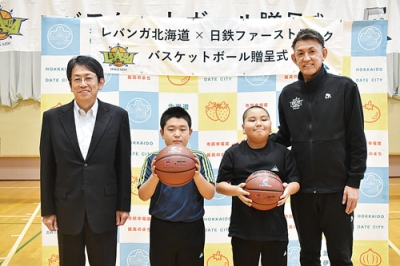 写真：関内小で児童にボールを贈った折茂社長（右端）と篠原社長（左端）