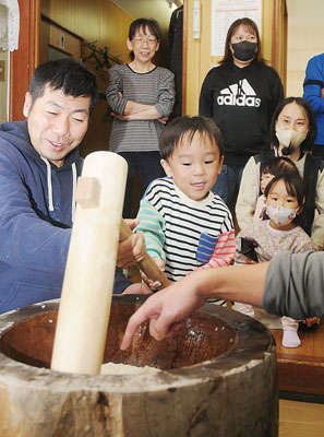 写真：元気よくきねを振り上げ、餅をつく参加者