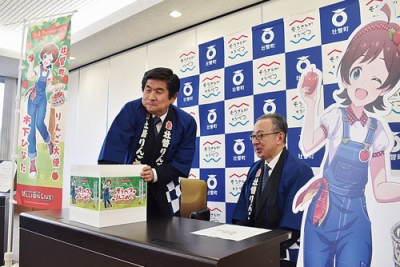 写真：賞品の当選者を抽選する髙井実行委員長（左）