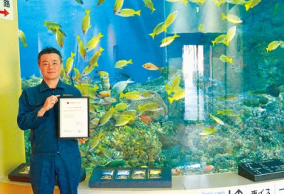 写真：アニマルウェルフェア基準認定証を手にする吉中館長