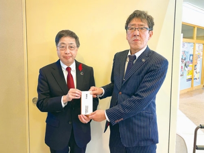 写真：室蘭民報社の山田繁樹・本社執行役員営業局長（右）と室蘭市共同募金委員会のの髙木康事務局長