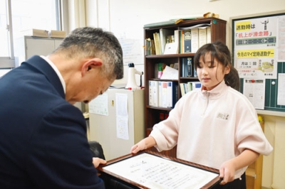 写真：社明運動作文コンテストの表彰状を受け取る安川さん
