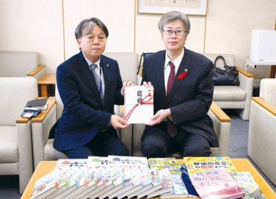 写真：堀井市長に目録を手渡す松川取締役