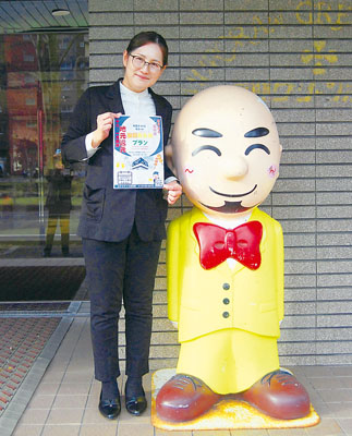 写真：プランの利用を呼びかけるフロントの鈴木さん