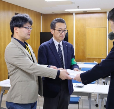 写真:泊原発3号機の再稼働に同意しないよう知事に求める署名を、道庁職員(右手前)へ手渡す「北海道平和運動フォーラム」の蒲池仁共同代表(中央)ら=5日午前、道庁